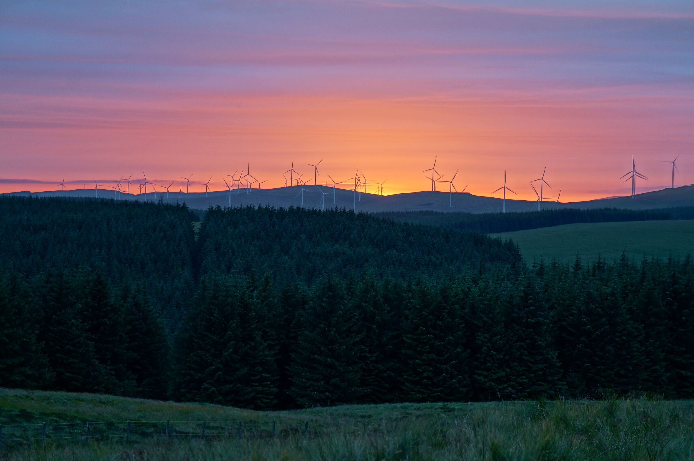 Wind turbines on distant hills at sunset